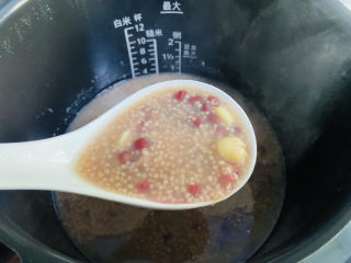红豆小米粥,待时间到，打开锅盖搅拌均匀。嗜甜者可以加入红糖或是冰糖