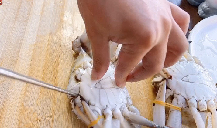 肉蟹煲,接下来处理最难的，活蟹！活着的蟹处理起来最难的是怕它夹手，所以先要把它弄死，只要一根筷子从蟹的嘴巴插进去，一会就死了。这样就不用担心切的时候夹手了。