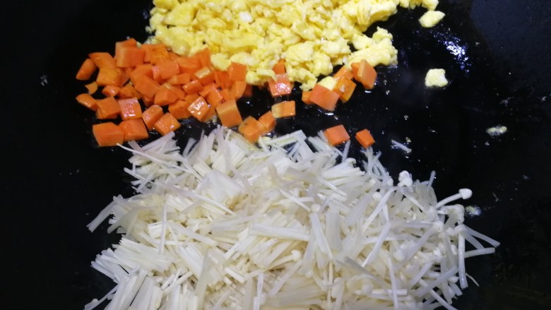 咖喱蛋炒饭,胡萝卜推到一边，放入金针菇，文火翻炒，把金针菇炒软。