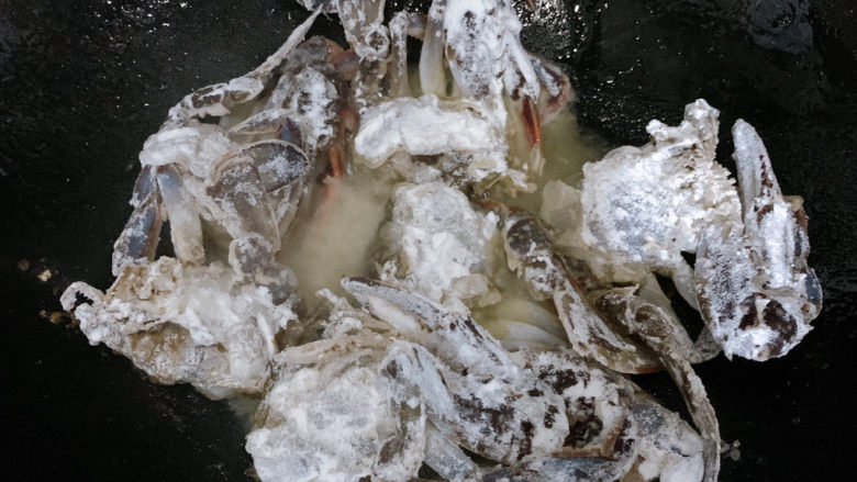 咖喱梭子蟹,锅中烧热油，七八成热的时候，将梭子蟹块放入其中。