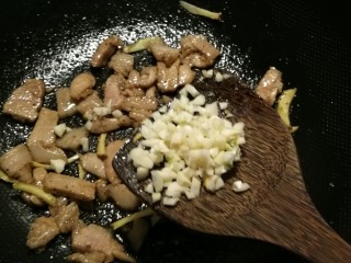 雪菜四季豆,肉片变色后放入蒜末炒出香味。