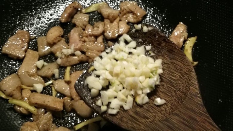 雪菜四季豆,肉片变色后放入蒜末炒出香味。
