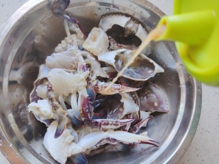 咖喱梭子蟹,梭子蟹处理干净，蟹腮一定要去干净哦！对半剪开，淋适量料酒，腌制一会儿