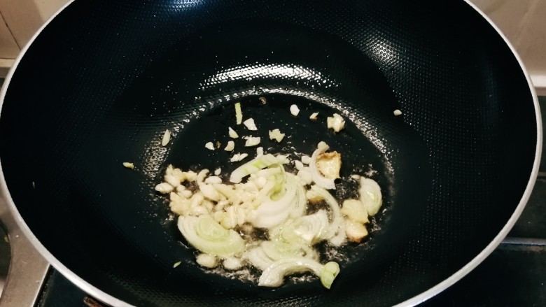 西芹炒鱿鱼,起油锅放入食用油 油热后放入葱姜蒜爆香。