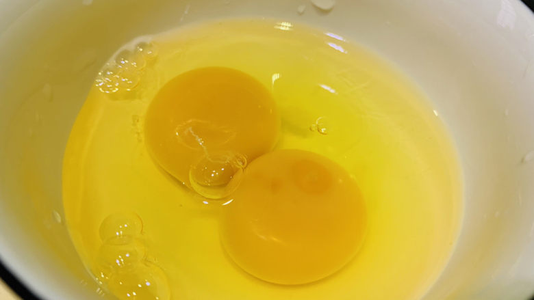 洋葱炒蛋,鸡蛋打入碗内