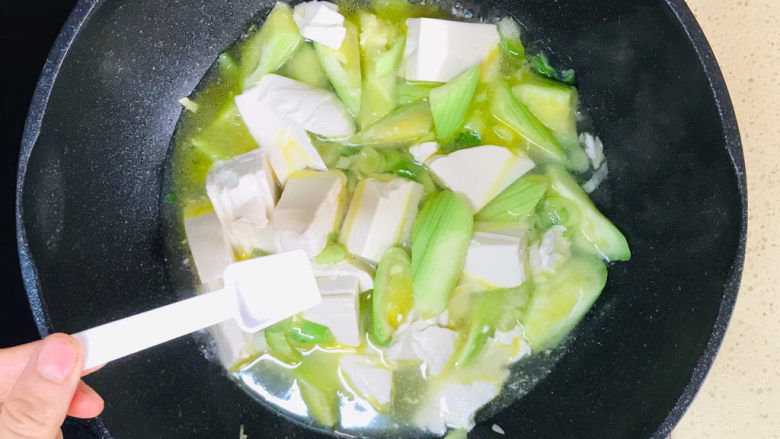 丝瓜炖豆腐,撒入盐调味