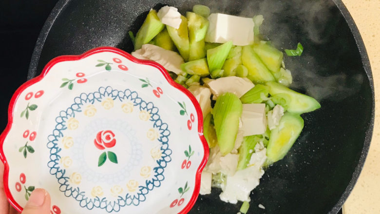 丝瓜炖豆腐,轻微翻炒均匀，加一碗清水，烧开
