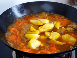红烧鲅鱼,倒入炸好的土豆跟鲅鱼块，大火烧开后转小火慢炖15分钟左右。