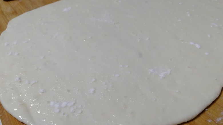 千层发面饼,取一份面剂擀成长方形面片，淋上少许食用用，刷子刷匀，洒上少许干面粉。
