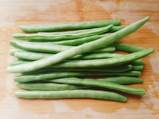 雪菜四季豆,准备适量四季豆摘去两边的茎膜， 洗净备用