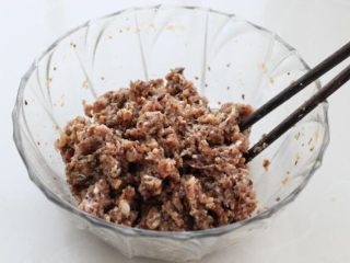 白菜包肉,取出打好的肉糜调入生抽、蚝油、盐和香油，用筷子搅拌均匀。