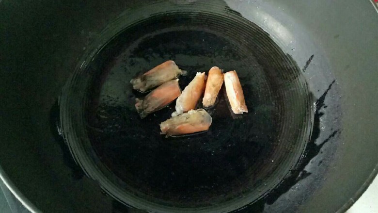 自制虾滑,锅中加入适量油，油热，下去虾头翻炒至变色，夹出虾丸