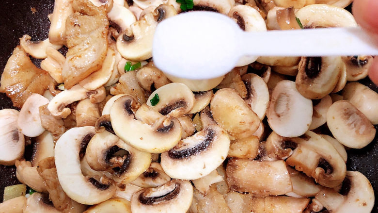 蘑菇炒肉,加入盐，放入少许水。