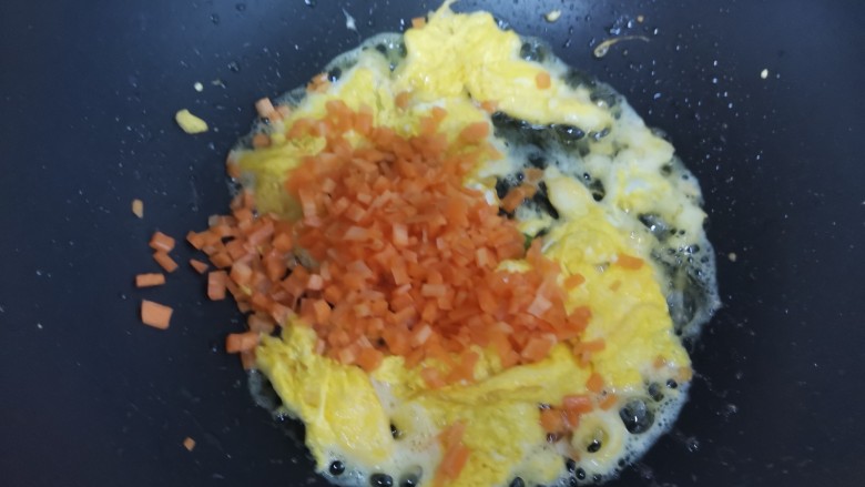 橄榄菜炒饭,待鸡蛋液凝固，炒散，下入胡萝卜丁翻炒