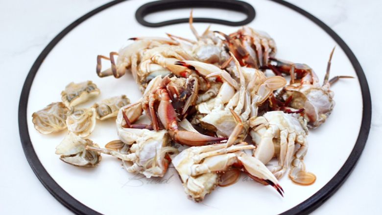 酱香花蟹,打开蟹盖，去掉胃部后，用刀把花蟹一切两开。