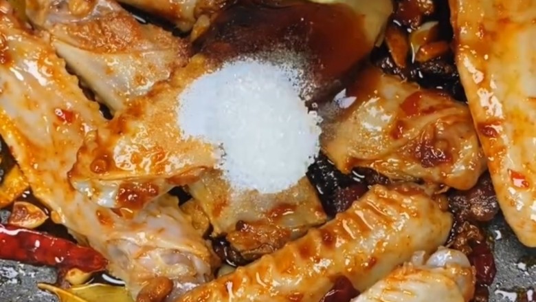 红烧鸭翅,再放入一勺盐一勺白糖翻炒至上色，盐是一种人人家中常备的一种调味品，每个菜都需要用到它。盐也可以有效的调味也可去除腥味。白糖只是调调甜味，不宜多食