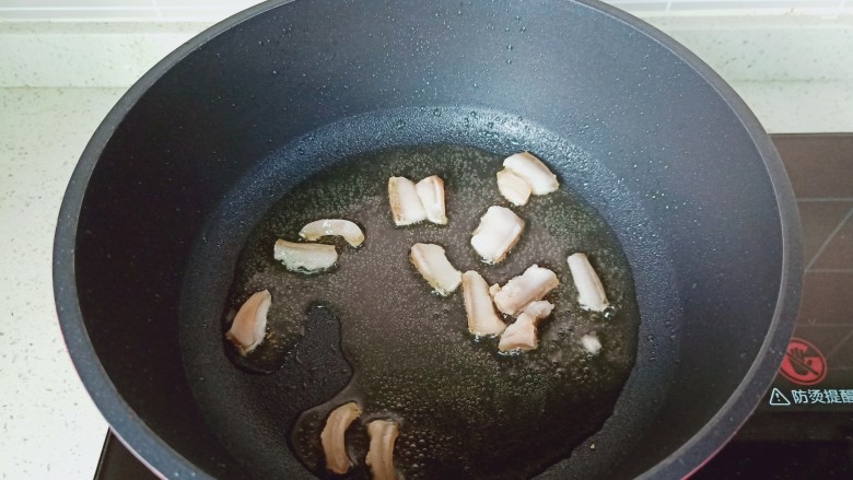 青椒炒豆干,锅里放适量的食用油，把肥肉煎一下。