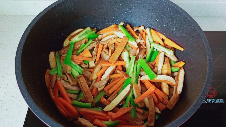 青椒炒豆干,最后加入青椒翻炒均匀。