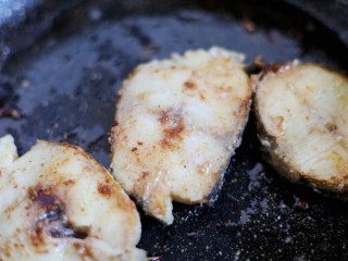 意式葱香煎鳕鱼,5. 捞出葱圈放入鳕鱼块煎至两面金黄。