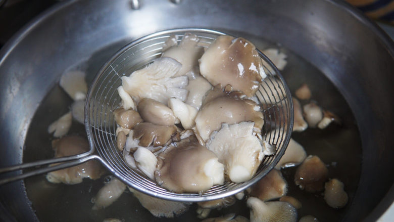 蘑菇炒肉,洗净的平菇入锅焯烫至水再次沸腾，捞出，控水