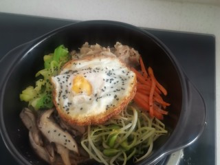韩式肥牛石锅拌饭,放鸡蛋，上面撒上黑芝麻