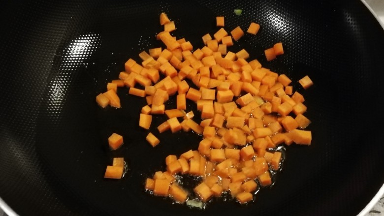 青椒炒玉米,起油锅放入食用油放入胡萝卜丁