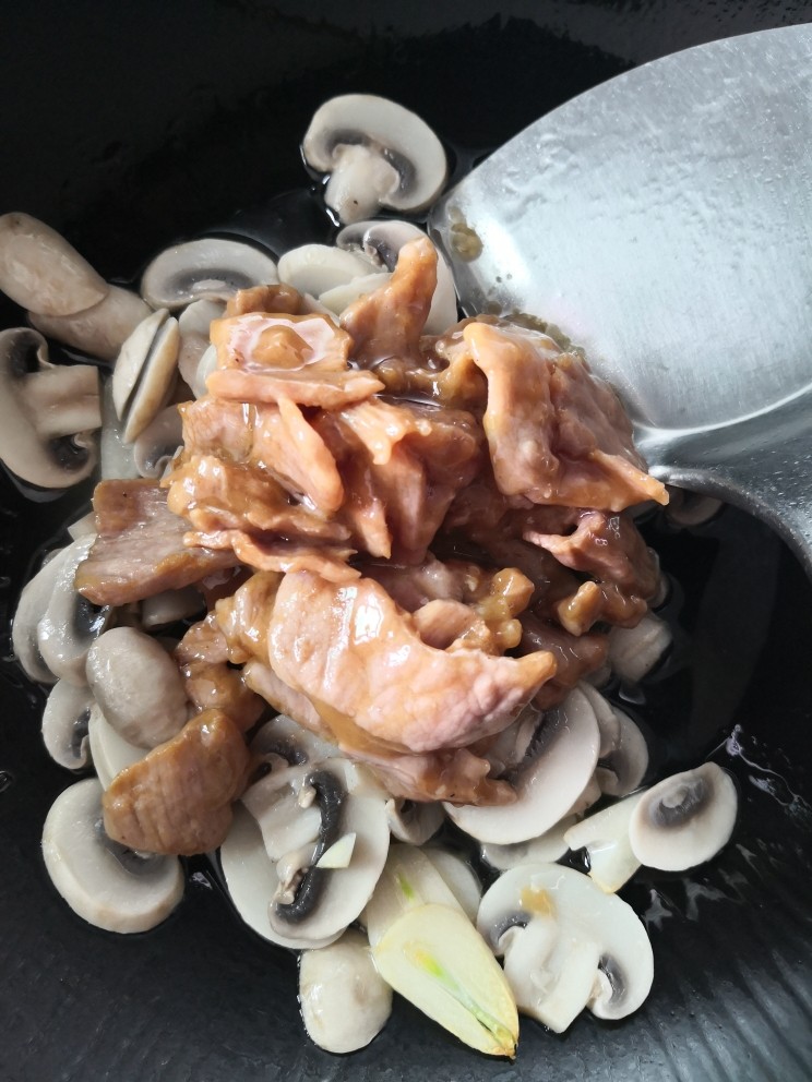 蘑菇炒肉,倒入肉片，继续翻炒至断生