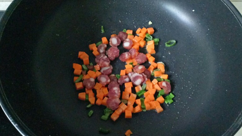 橄榄菜炒饭,加入腊肠片翻炒至腊肠变成透明的时候