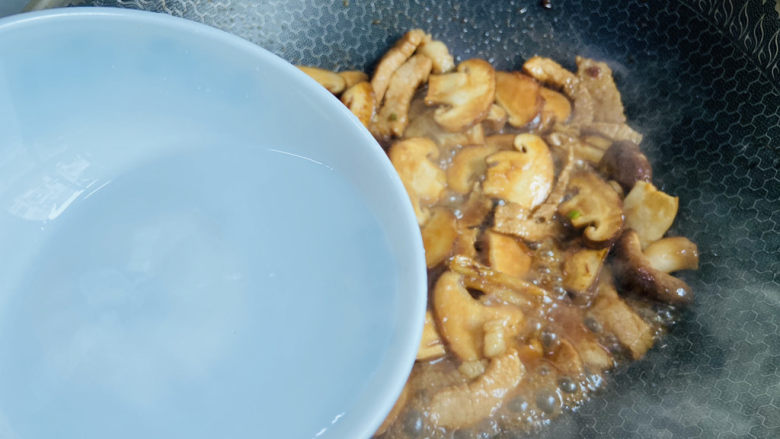 蘑菇炒肉,加入适量热水翻炒至断生