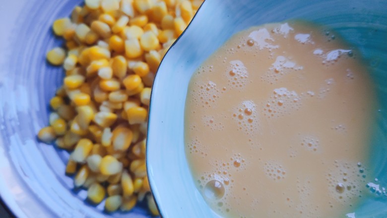 椒盐玉米,将玉米粒放入大碗内，倒入鸡蛋液
