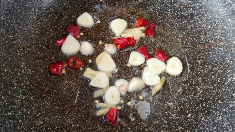 蘑菇炒肉,炒锅内继续倒油烧热，下入蒜片、姜丝和干红辣椒炒香。