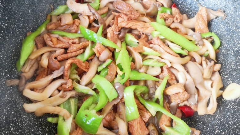 蘑菇炒肉,下入青椒丝翻炒至断生。
