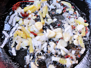红烧鸭翅,锅中倒入底油加热放入花椒和八角炸香再放入葱姜蒜爆香