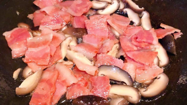 奶油蘑菇意面,锅中放入底油加热放入培根炒出香味再放入香菇炒匀