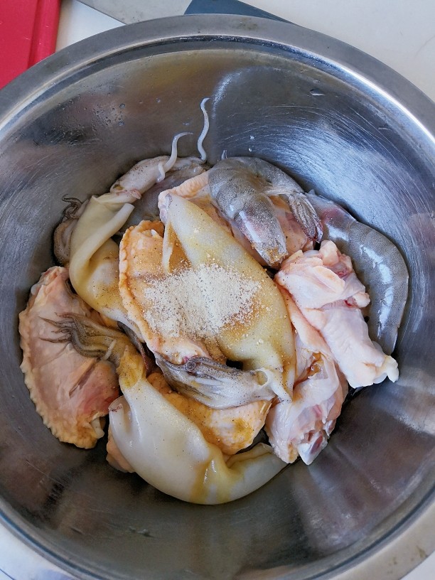 三汁焖锅,处理好的鲜虾、海兔、鸡翅中、翅根用料酒、生抽、胡椒粉腌制30分钟。