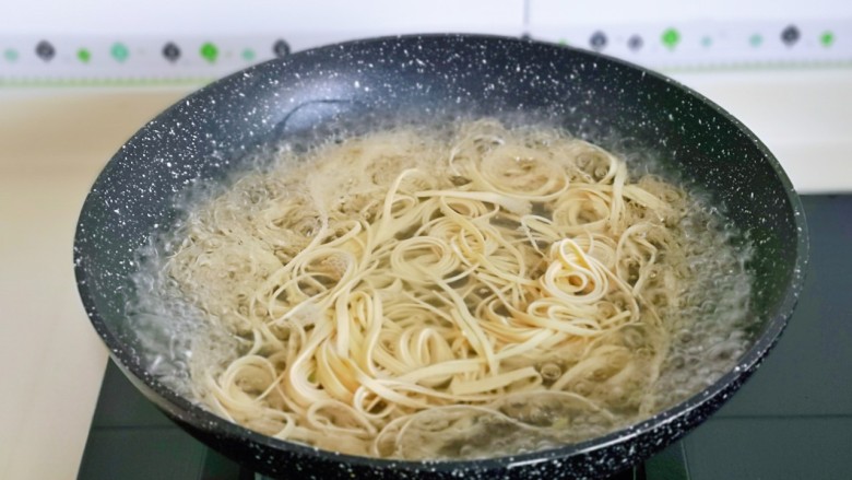 青椒炒千张,锅中加入水烧开，下千张丝煮2分钟捞出备用。