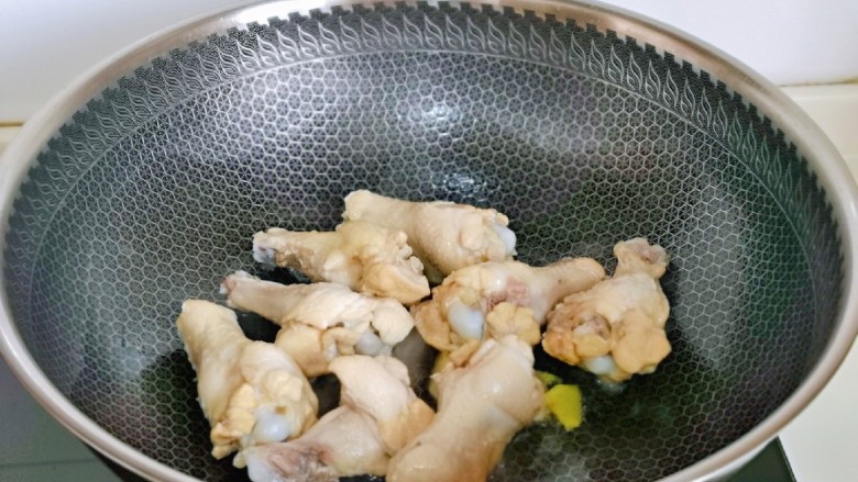 鸡腿炖蘑菇,起油锅，加入姜片煸炒，再加入鸡翅根煎至微黄。