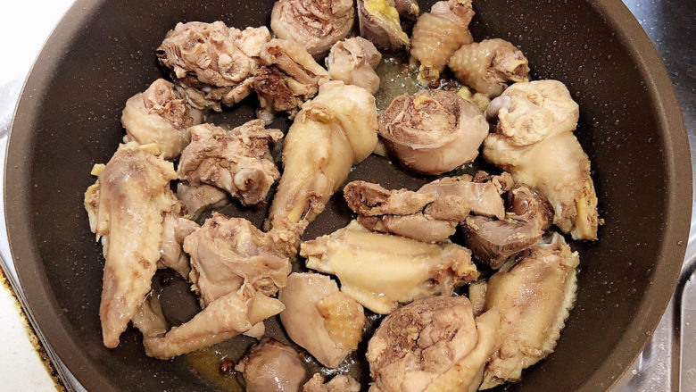鸡腿炖蘑菇,白糖融化，放入鸡腿肉，翻炒均匀。