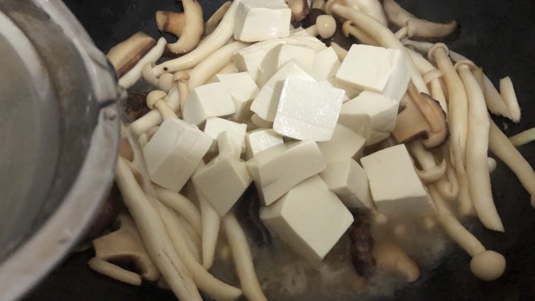 蘑菇炖豆腐,豆腐倒下去，再加入适量的水焖一会