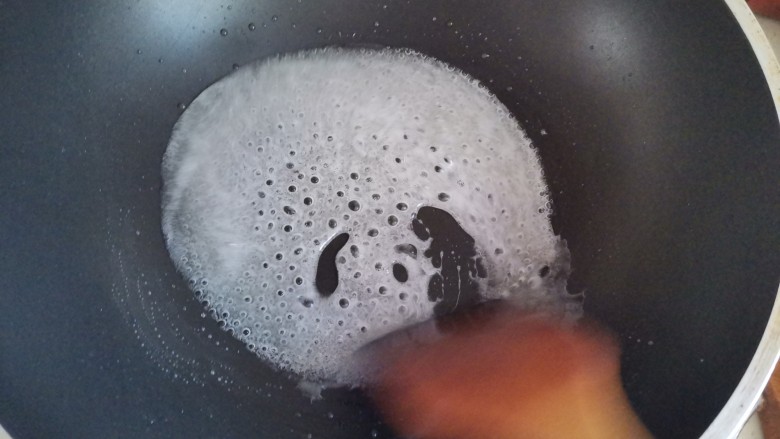 酸酸甜甜～雪花山楂球,熬至冰糖全部融化，转小火继续熬至出来绵密的小泡泡，这个熬的过程是把水分全蒸发掉