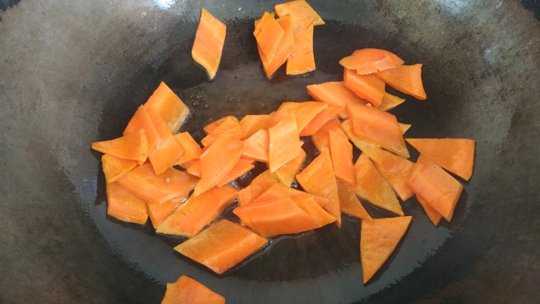 青椒炒胡萝卜,锅中放入适量植物油，放入胡萝卜翻炒至变软，盛出待用