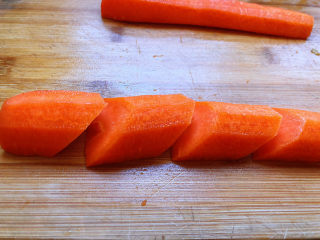 青椒炒胡萝卜,这里有一个切菱形片的小窍门，用这个方法很简单就能切除漂亮的菱形片。对半切开的胡萝卜，斜切一刀，去掉胡萝卜根部的部位，使其呈斜面状，然后，间隔一寸长度，再斜切，以此类推