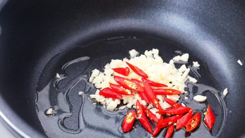 酸辣娃娃菜,锅中加入适量的食用油烧热，放入蒜末和小米椒