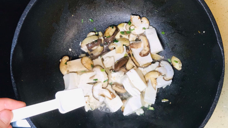 蘑菇炖豆腐,撒入盐调味