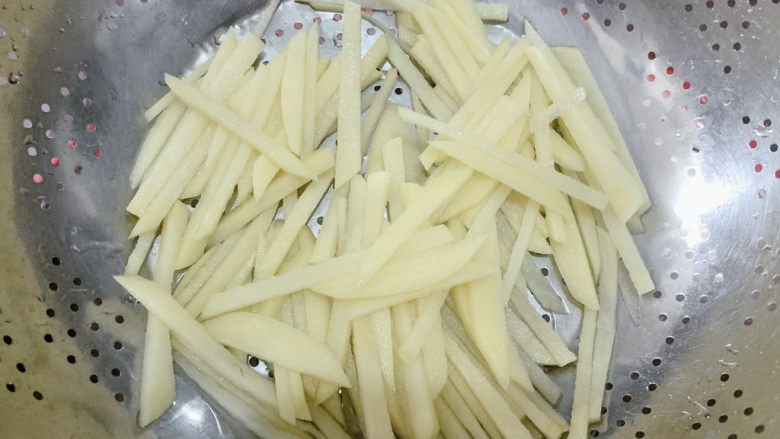 尖椒土豆片,冲洗一下，洗去多余淀粉，这样能让炒出来的土豆丝更脆爽。