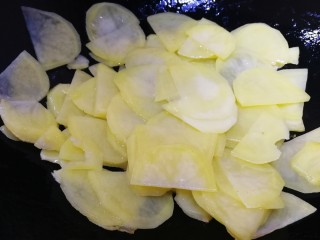 尖椒土豆片,油温5成热放土豆片，文火翻炒大约1分钟，土豆片炒半透明。