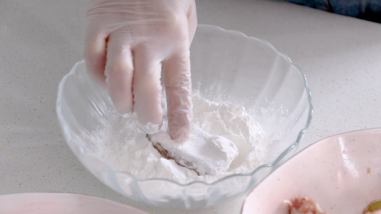 椒盐排骨,淀粉平铺在盘子里，将排骨两面都裹上生粉，放置三分钟返潮