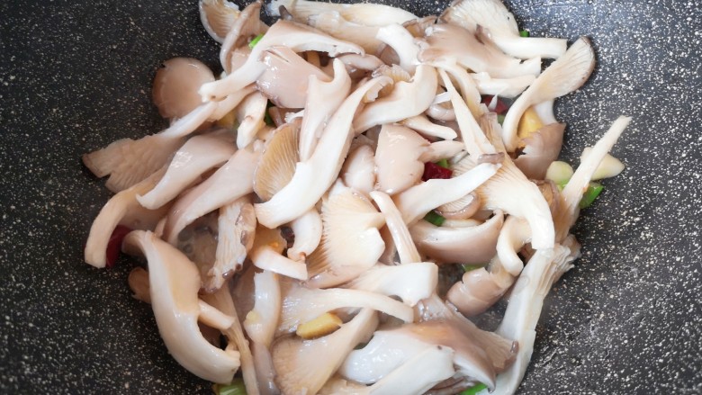 蘑菇炖豆腐,下入蘑菇翻炒至变软。