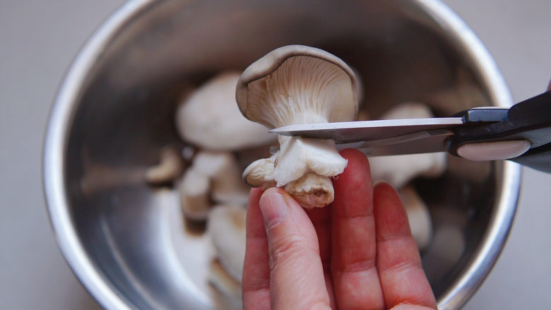 蘑菇炖豆腐,平菇用厨房剪刀去掉蒂部，流水冲洗干净小伞下的泥沙