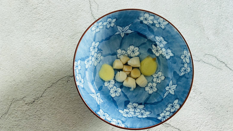 瑶柱蒸蛋,瑶柱清洗一下放入碗中加入两片姜片、适量清水浸泡至软